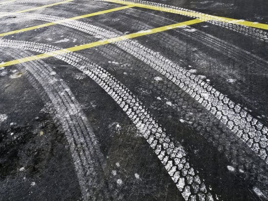 Automotive tire tracks from road salt on asphalt pavement in winter, northern Illinois