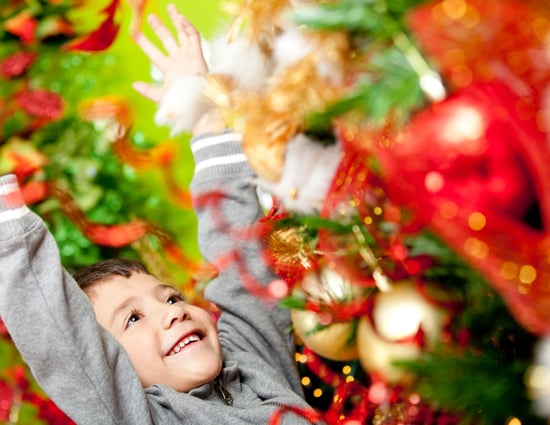 Excited boy enjoying Christmas next to the tree