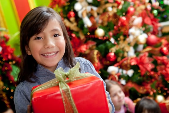 Girl holding a Christmas present and smiling