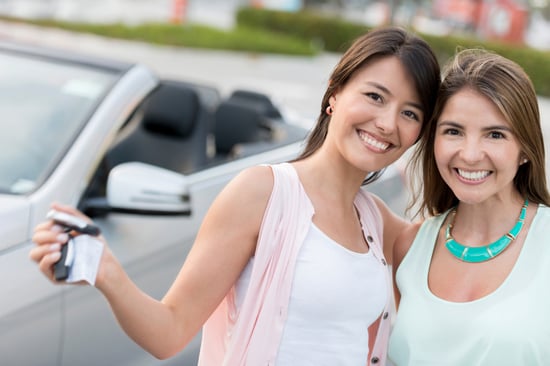 Happy girls going on a road trip and holding car keys