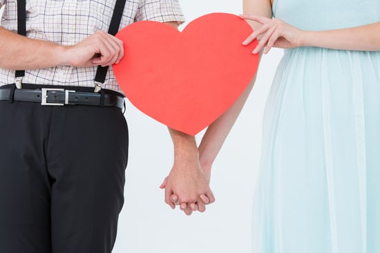 Hipster couple holding heart card on white background