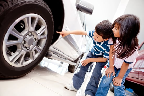 Kids in the dealer looking at car wheels