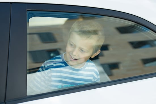 Smiling little boy looking out in the window car