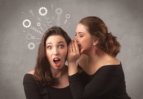Two girlfriends in elegant black dress sharing secrets with each other concept with drawn rack cog wheels and spiral lines on the wall background.
